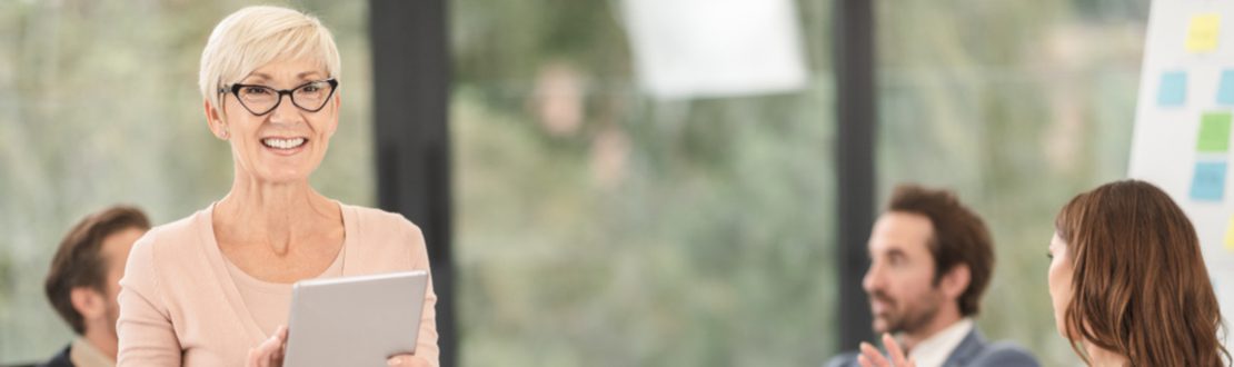 Сотрудница с планшетом на совещании в офисе
